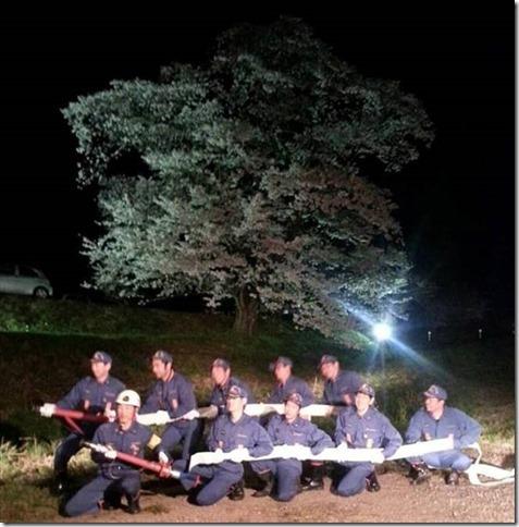 消防団の方が般若寺の一本桜の前で消防ホースを持っている様子がライトに照らされている写真